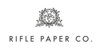 A logo featuring elegant typography and a decorative floral wreath, representing Rifle Paper Co., known for stationery and art.