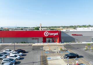 A bright, spacious exterior of a Target store featuring order pickup and nearby CVS pharmacy, surrounded by a parking lot filled with cars.